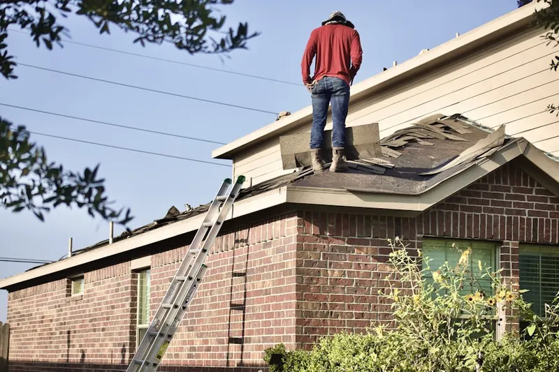 Professional roofer working on a residential roof in Brookline